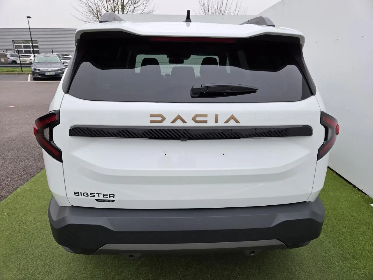 Vue arrière du Dacia Bigster blanc glacier avec logo brun cuivré et feux arrière en forme de C.