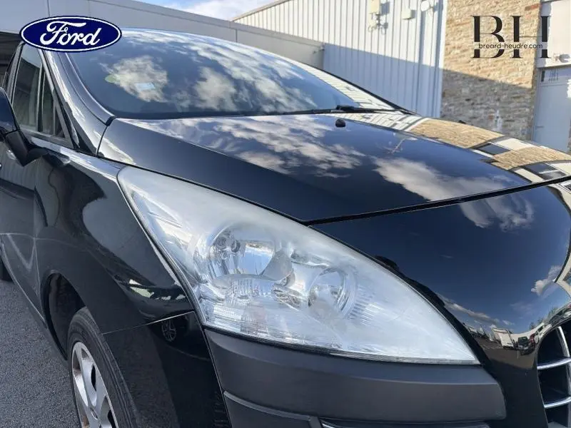 Vue 3/4 avant gauche d’un Peugeot 3008 noir Perla Nera avec phares halogènes et calandre chromée visible.