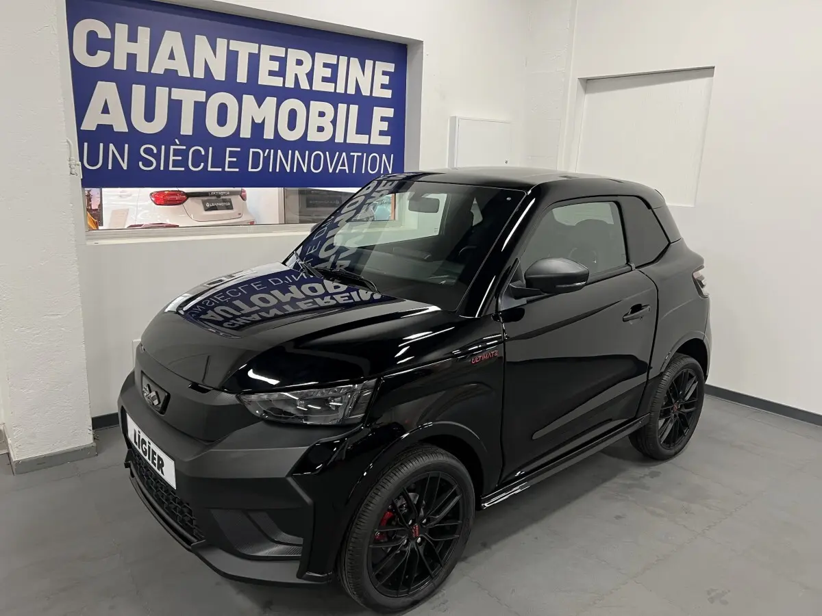 Vue 3/4 avant droite d'une LIGIER JS50 noire mate avec jantes alu noires et badge Ultimate visible sur l'aile.