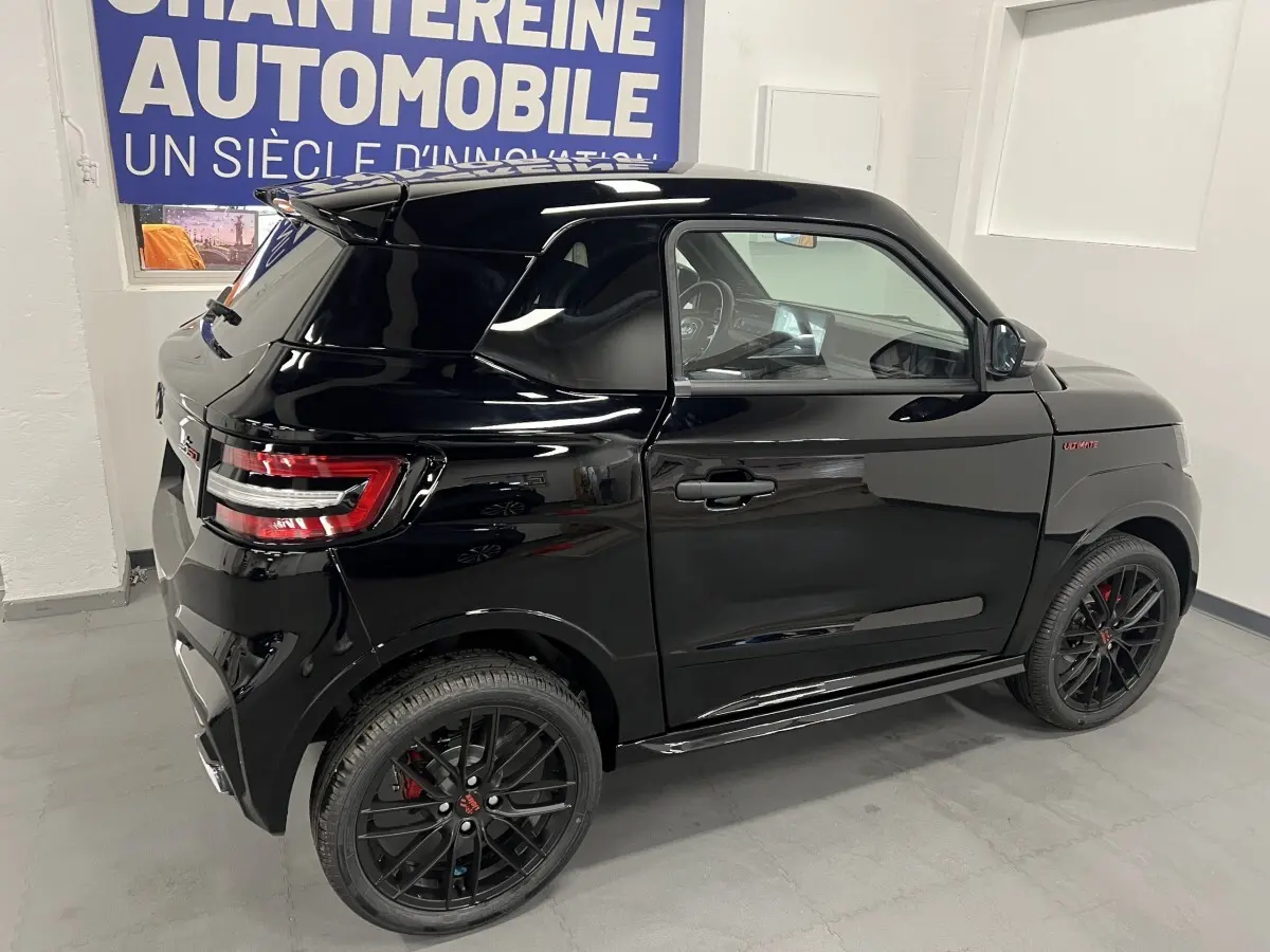 Vue 3/4 arrière droite de la LIGIER JS50 noire avec jantes alu noires mates et badge Ultimate sur l'aile avant.