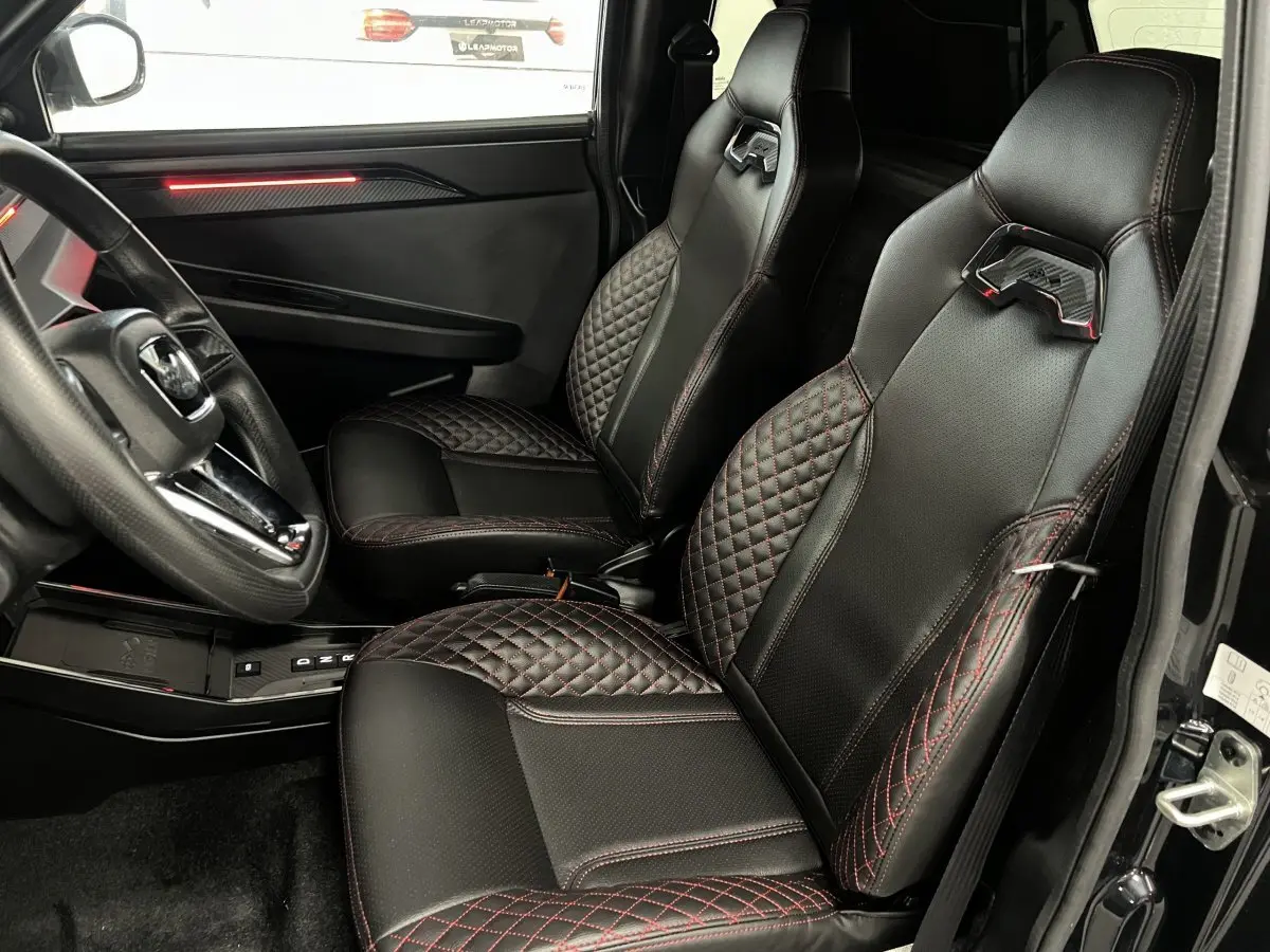 Vue intérieure côté conducteur de la LIGIER JS50 noire, sièges Ultimate en cuir noir avec surpiqûres rouges.