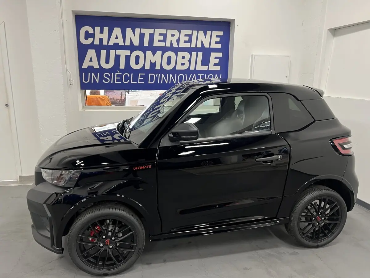 Vue de profil côté gauche d'une Ligier JS50 0.5 REVO D+ ULTIMATE noire avec jantes alu noires mates et badge Ultimate rouge.