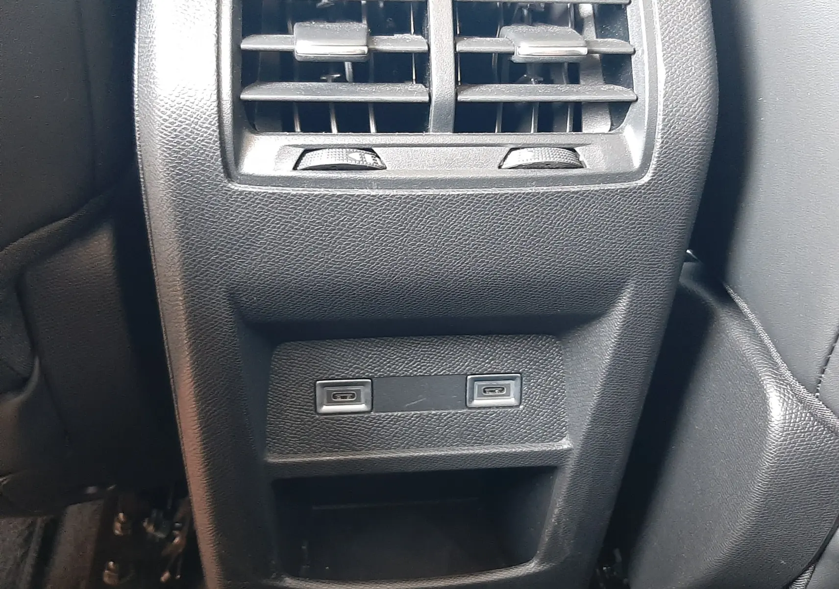 Vue rapprochée de la console arrière noire du DS4 2024 avec bouches d’aération et deux ports USB intégrés.