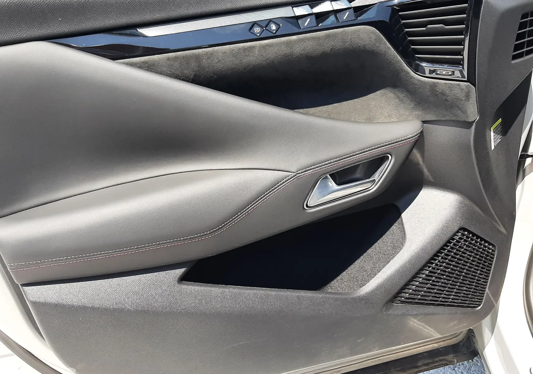 Gros plan sur la porte côté gauche du DS4 2024 blanc Cristal Pearl, avec garniture noire et commandes de fenêtre intégrées.