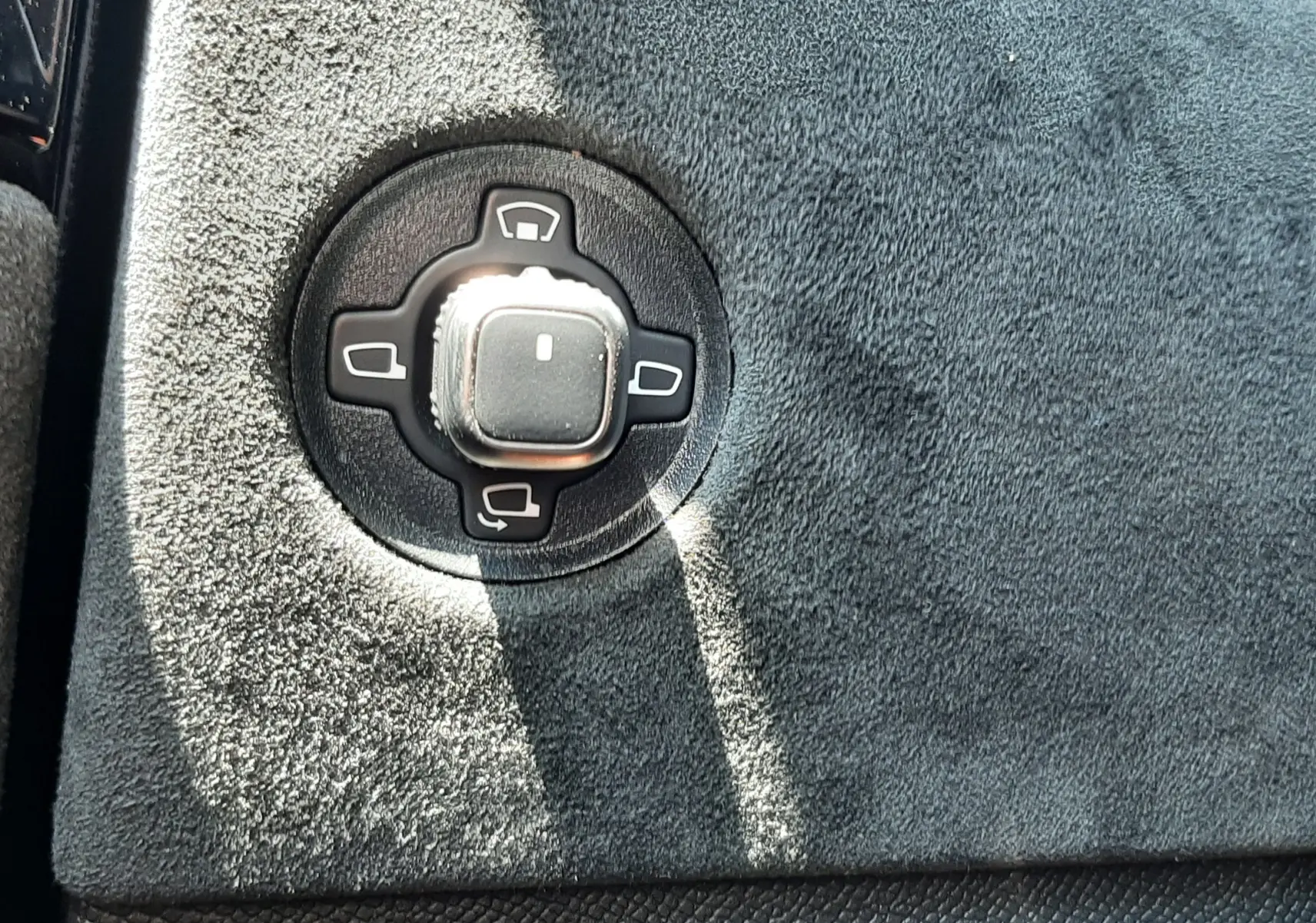 Gros plan sur le bouton de réglage des rétroviseurs sur la garniture noire texturée intérieure d'une DS4 Cristal Pearl 2024.