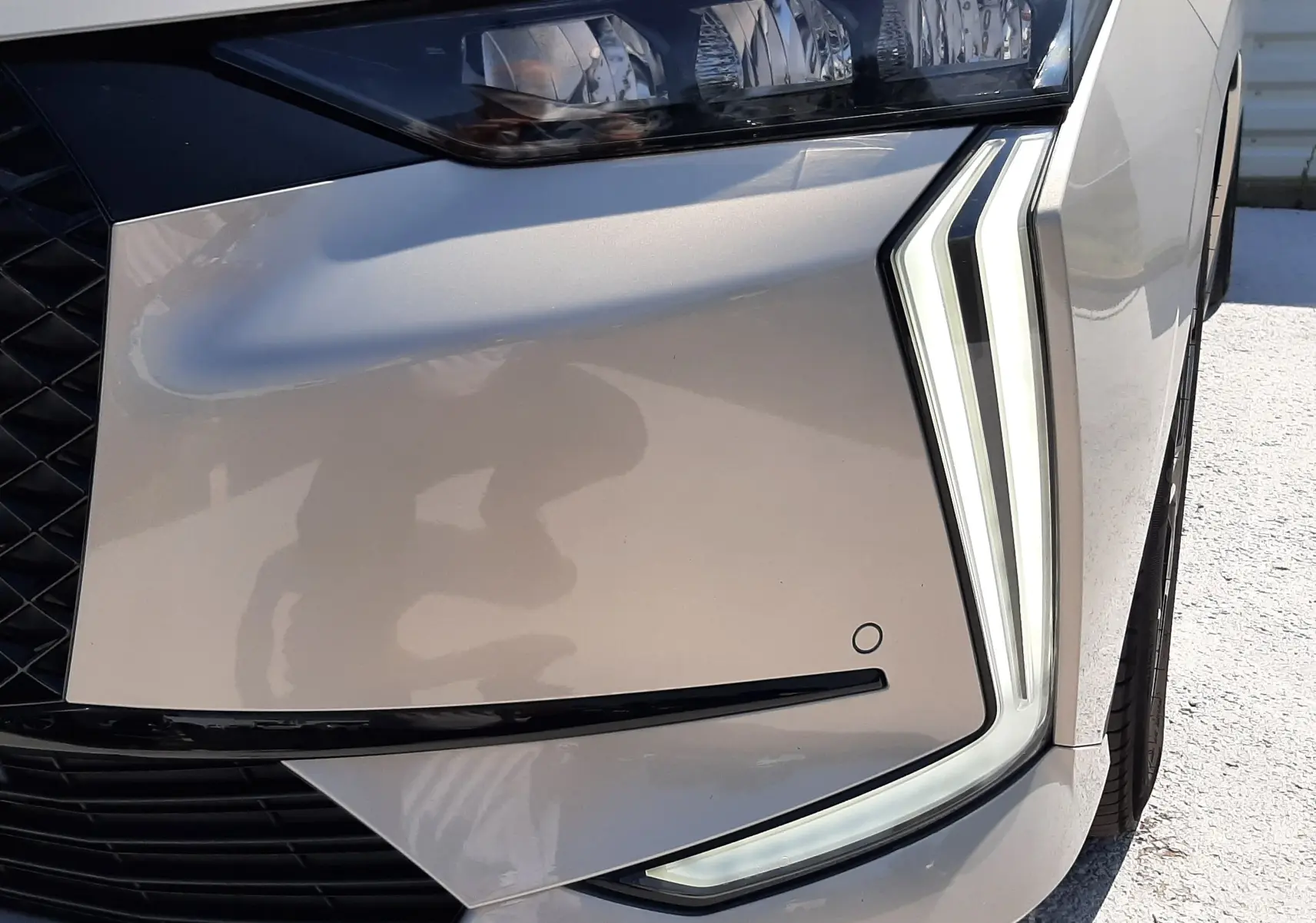 Gros plan sur le phare avant droit du DS4 2024 en Cristal Pearl, mettant en valeur ses feux LED distinctifs en forme de dents.