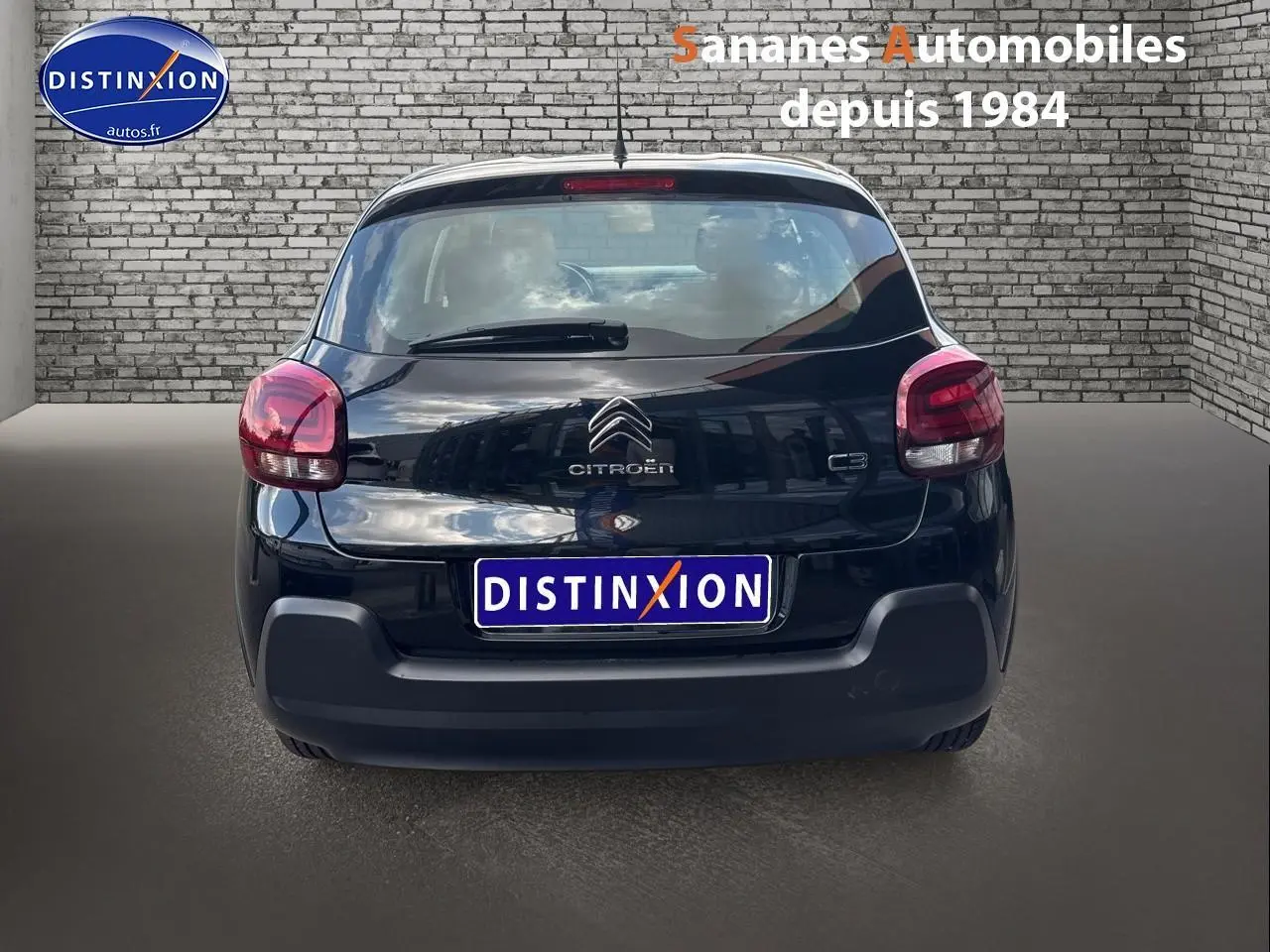 Vue arrière d'une Citroën C3 noire 2023 avec logo et feux arrière arrondis dans un décor urbain.