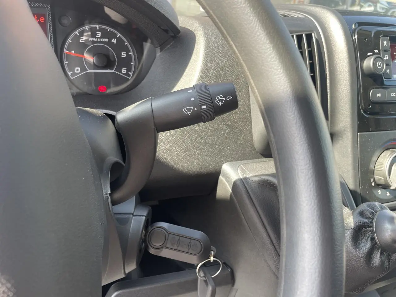 Vue rapprochée de l'intérieur du Citroën Jumper 2023 montrant le volant, le compteur et la clé de contact insérée.