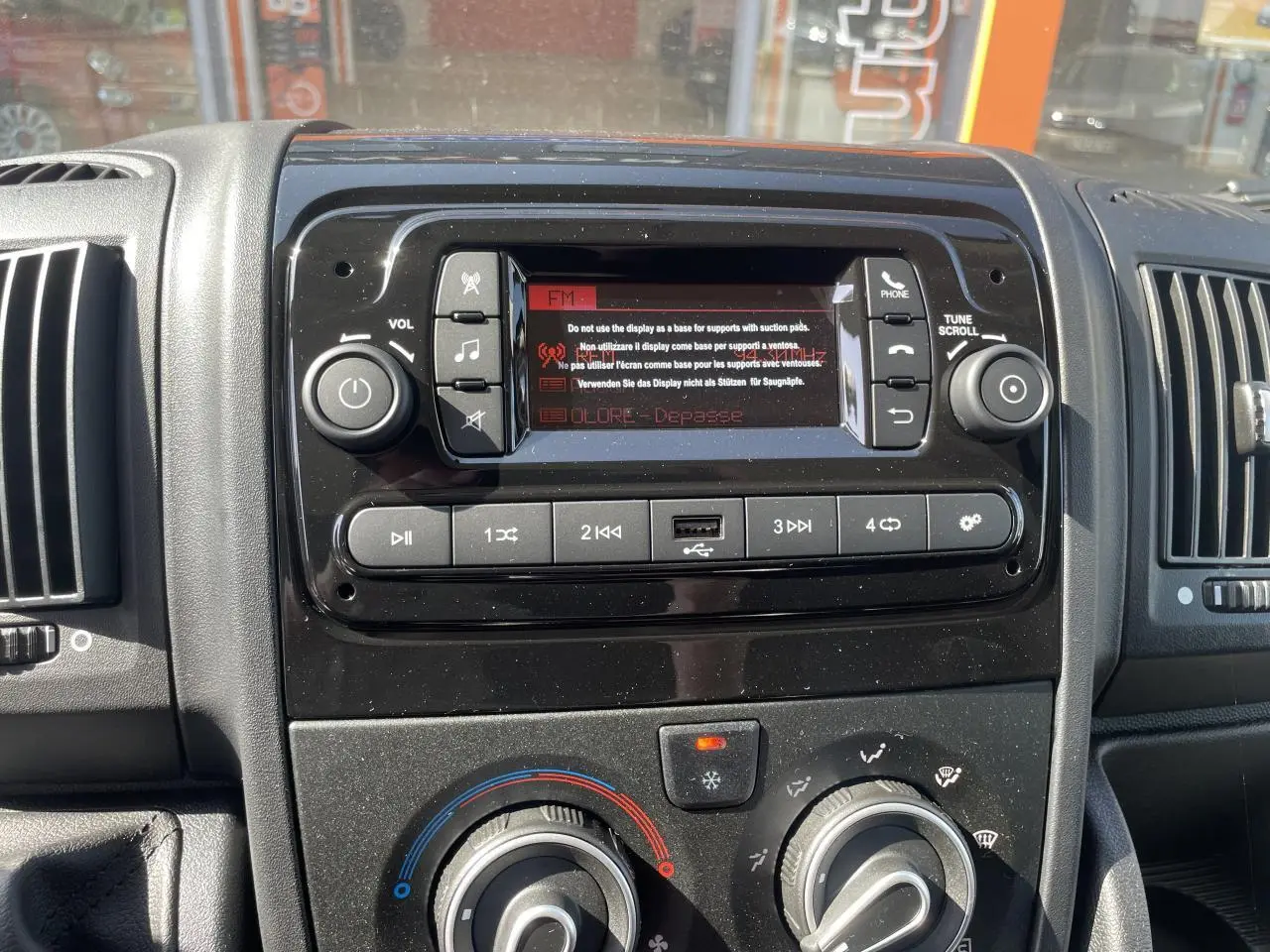 Tableau de bord noir du Citroën Jumper 2023 avec système audio, commandes climatisation et port USB visible.