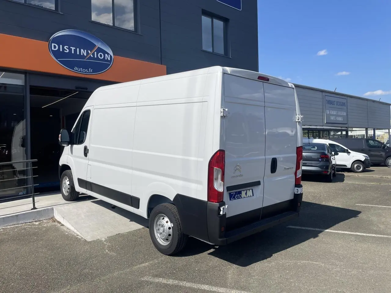 Vue 3/4 arrière droite d'un utilitaire blanc Citroën Jumper 2023 avec portes arrière tôlées et jantes acier.