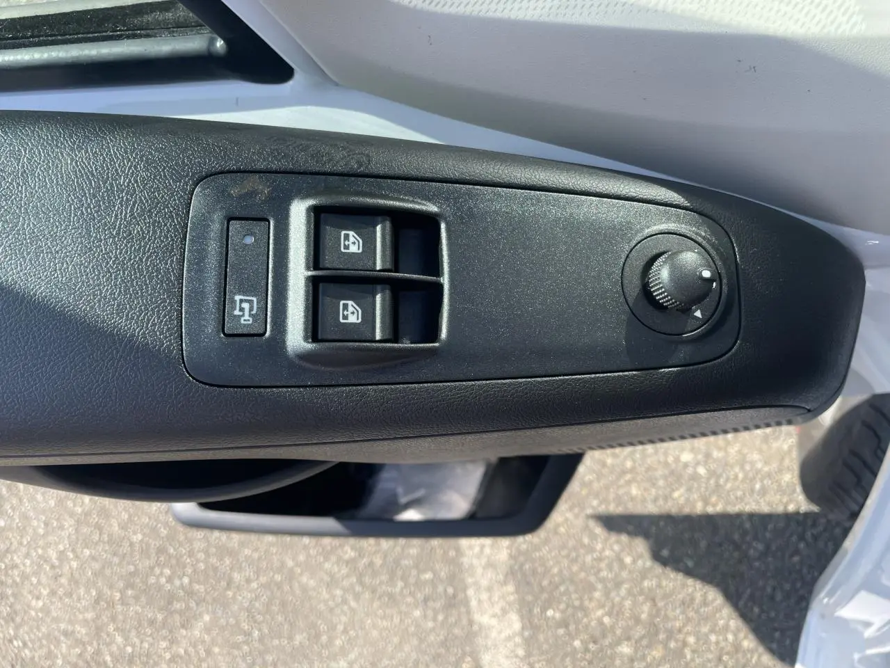 Gros plan sur la commande des vitres électriques et réglage des rétroviseurs côté gauche d'un Citroën Jumper blanc 2023.