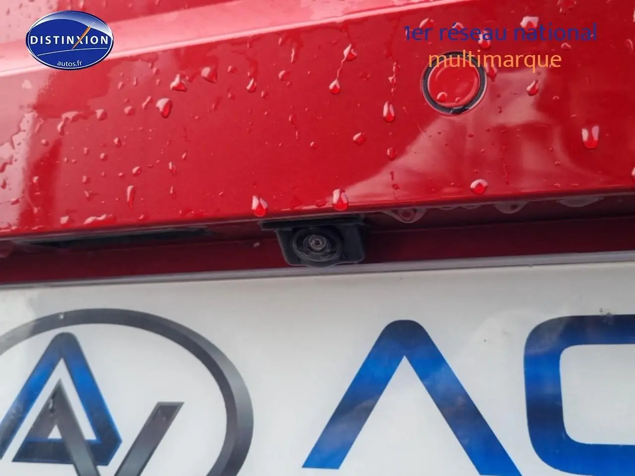 Gros plan sur la caméra de recul et capteur de stationnement sur le hayon rouge désir d'une SEAT Ibiza 2025.