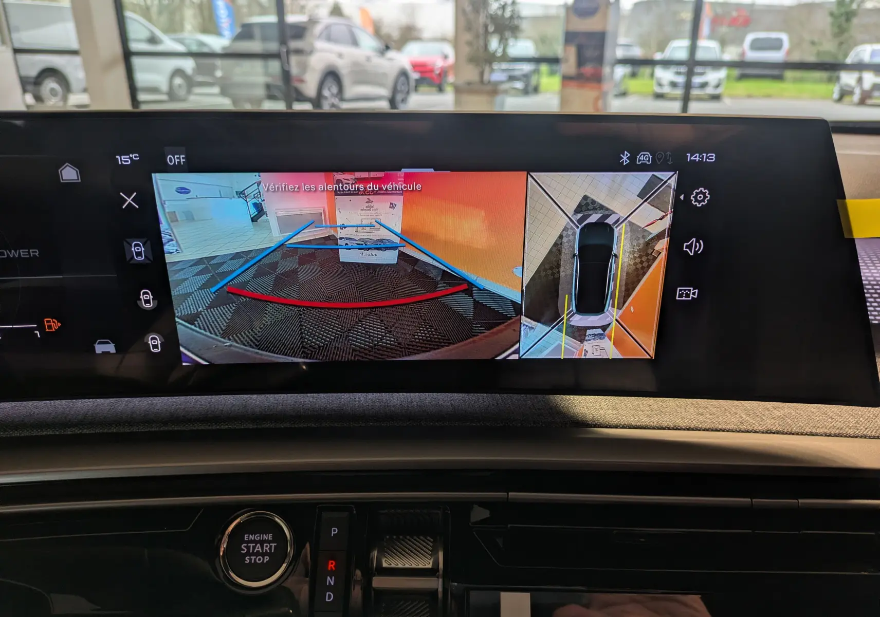 Vue intérieure du tableau de bord du Peugeot 3008 blanc, écran affichant la caméra de recul et la vision 360° en marche.