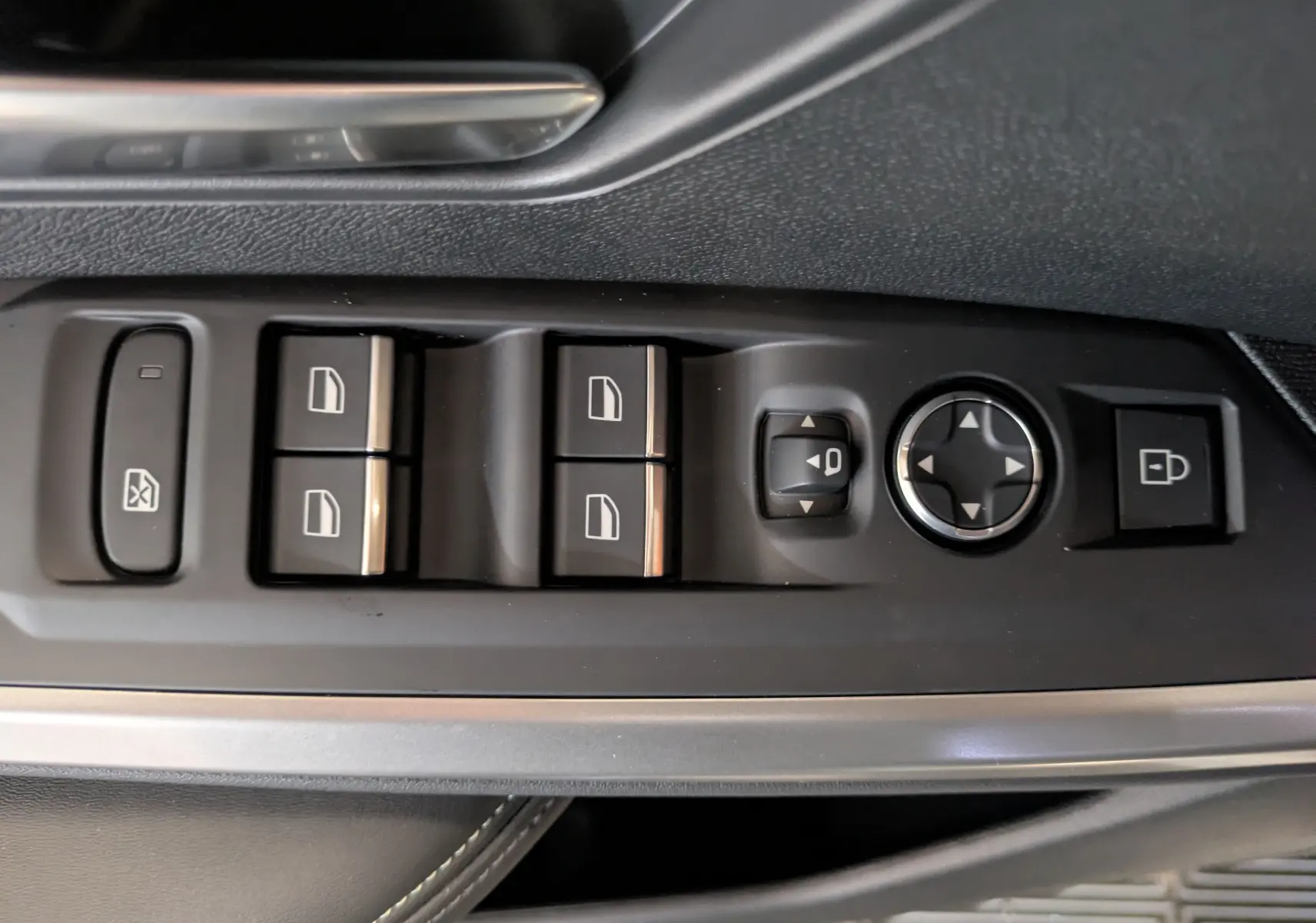 Vue rapprochée des commandes de lève-vitres et réglage des rétroviseurs côté conducteur du Peugeot 3008 blanc Okenite.