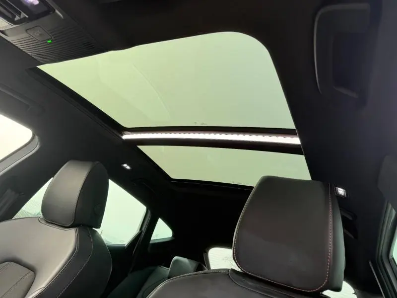 Vue intérieure du toit panoramique et des sièges avant en cuir noir du CUPRA Formentor blanc Nevada 2025.