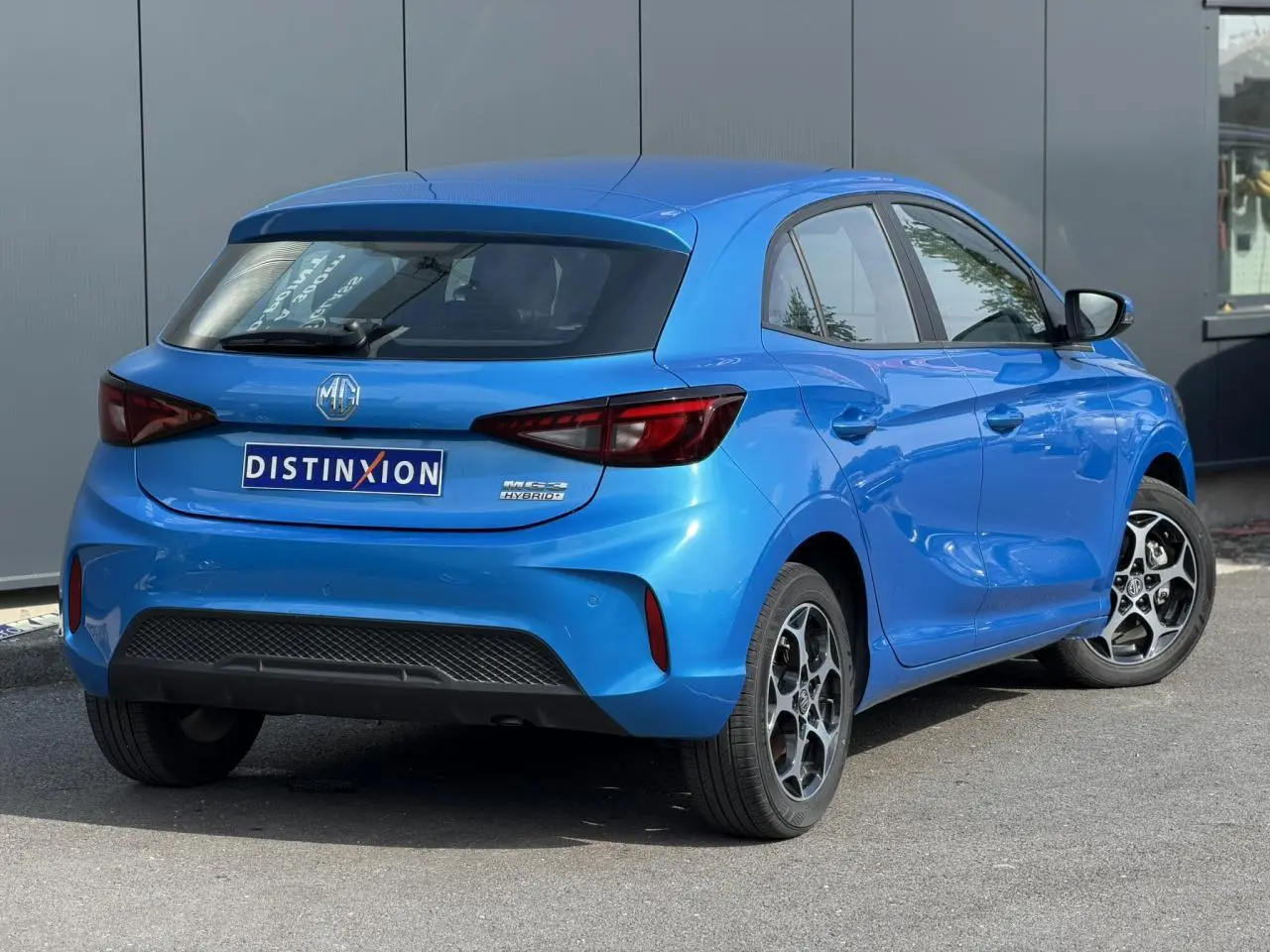 Vue 3/4 arrière droite d'une MG3 1.5 Hybrid+ 195 Comfort bleu Como avec jantes alliage et feux LED.