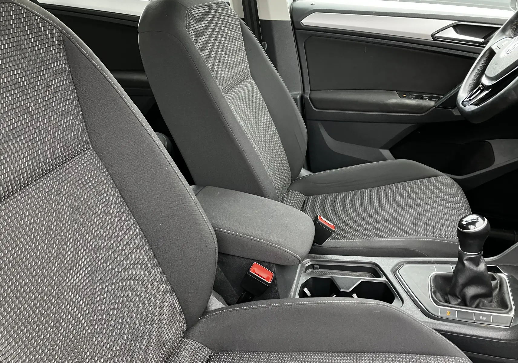 Intérieur avant du Volkswagen Tiguan 2018, sièges tissu gris et levier de vitesse manuel visible côté droit.