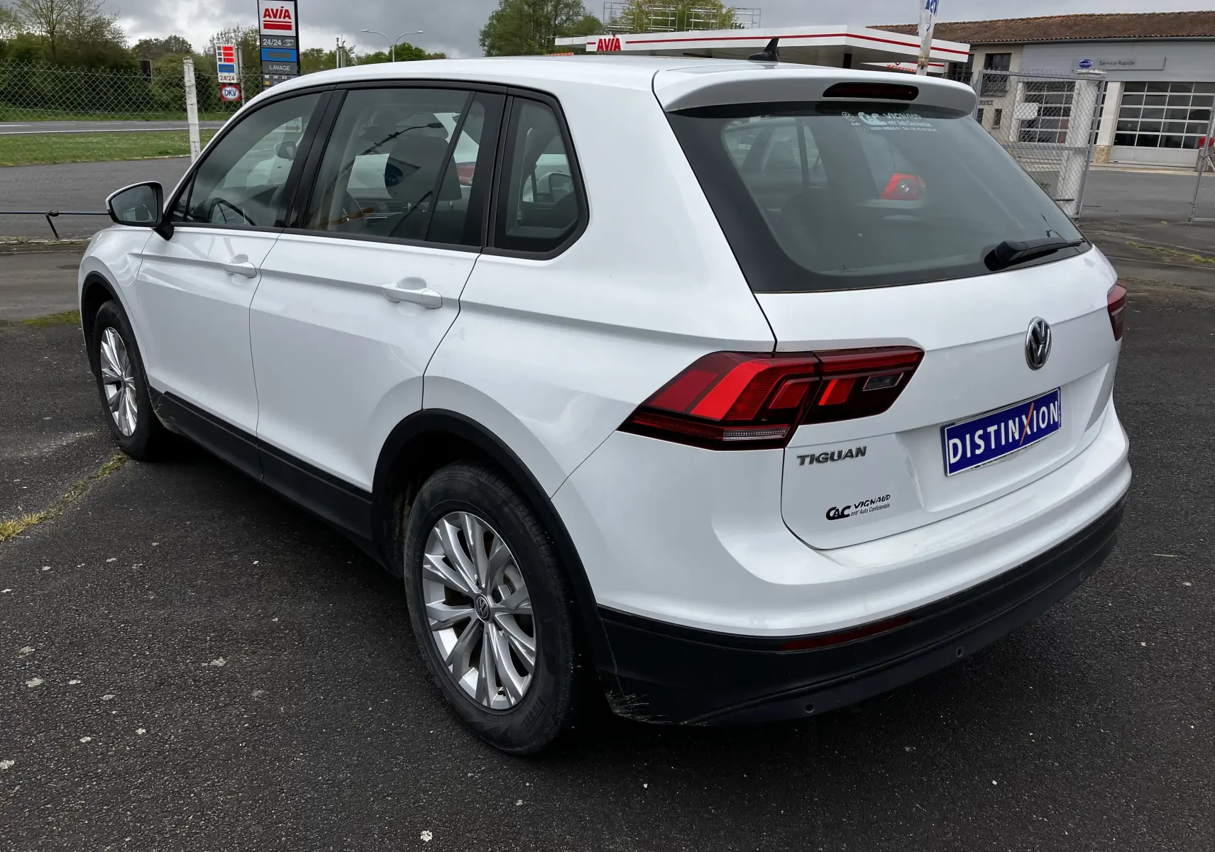 Vue 3/4 arrière droite d'un Volkswagen Tiguan blanc 2018 avec feux arrière LED et badge Tiguan visible.