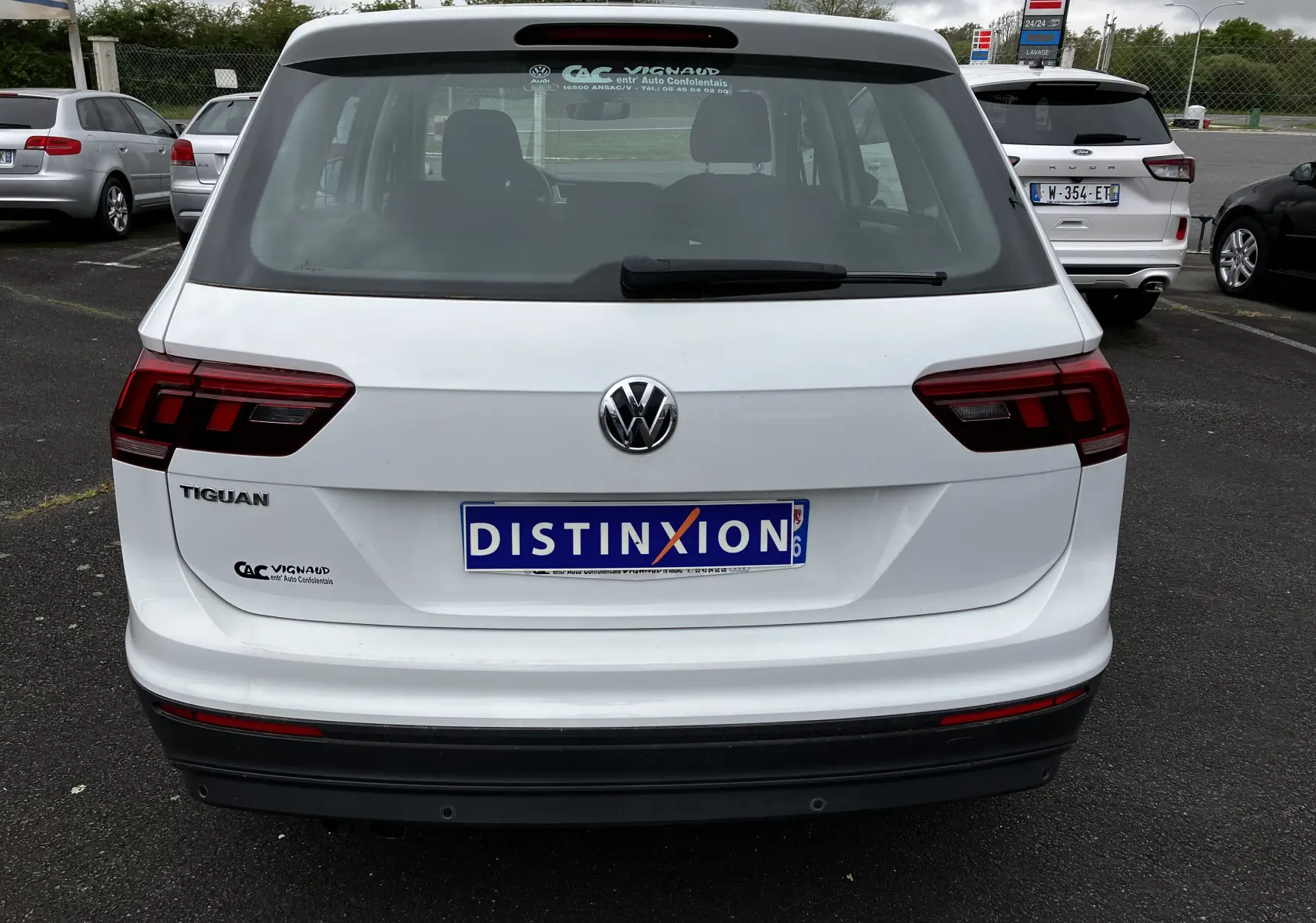 Vue arrière d'un Volkswagen Tiguan blanc de 2018 avec logo et plaque d'immatriculation Distinxion visible.