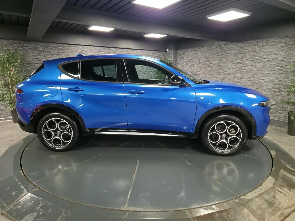 Profil droit d'une Alfa Romeo Tonale 2024 bleu métallisé avec jantes alliage 18 pouces et rétroviseurs noirs brillants.