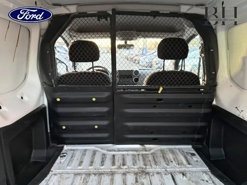 Vue intérieure arrière du Citroën Berlingo blanc 2017 avec cloison tubulaire et espace de chargement visible.