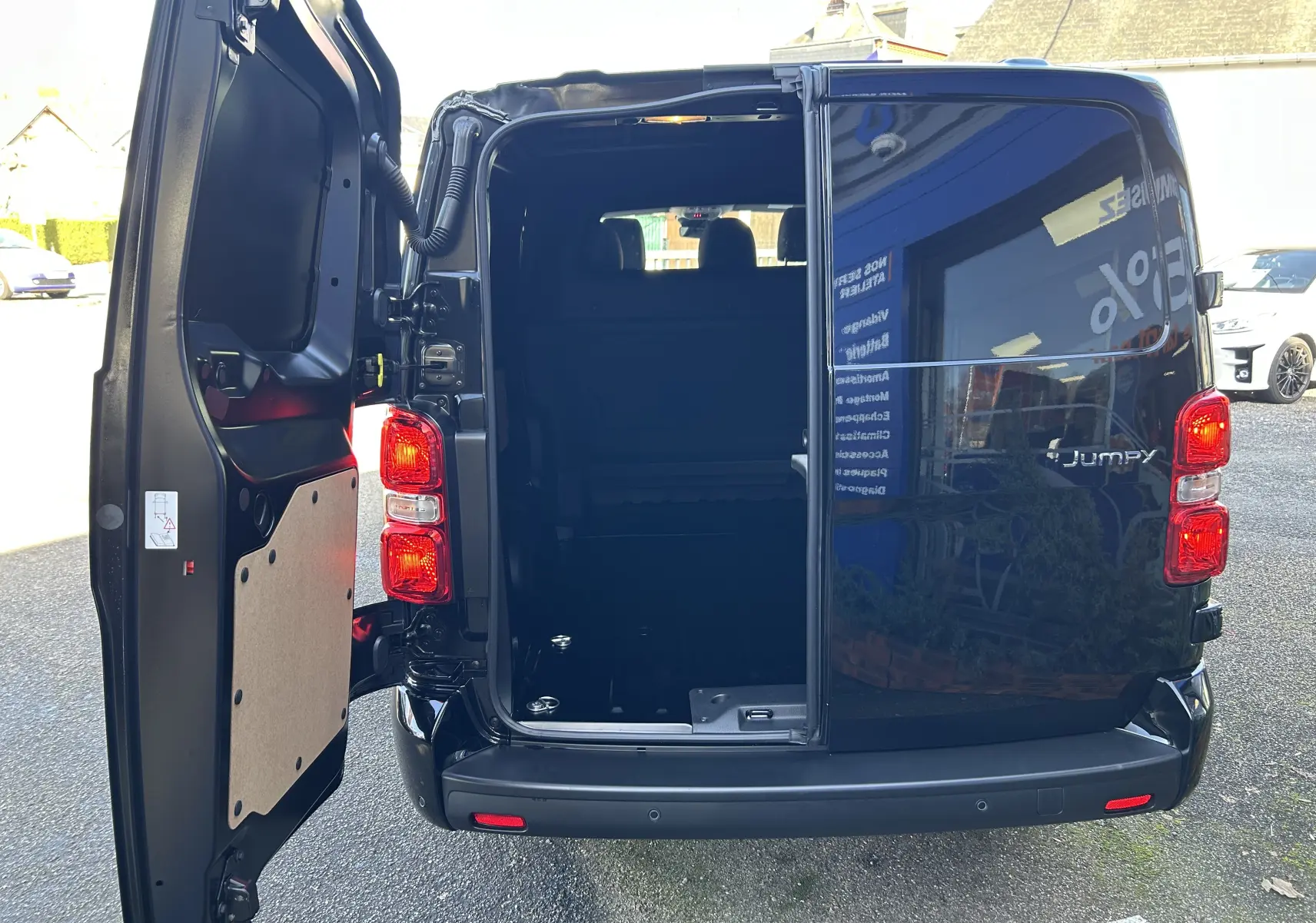 Vue arrière gauche ouverte du Citroën Jumpy Cabine Approfondie noir, montrant l’espace de chargement vide et la porte battante.
