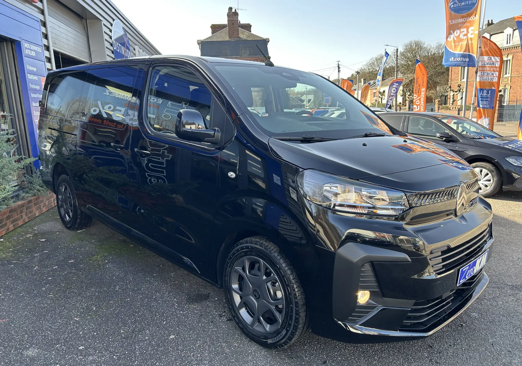 Vue 3/4 avant gauche d’un Citroën Jumpy Cabine Approfondie noir avec jantes tôle noires et projecteurs allumés.