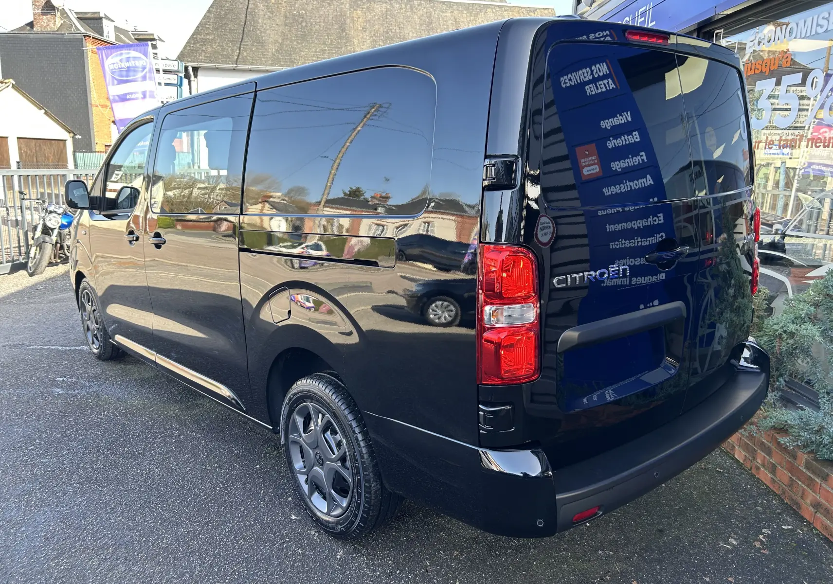 Vue 3/4 arrière droite d’un Citroën Jumpy Cabine Approfondie noir métallisé avec jantes tôle noires et porte latérale coulissante.