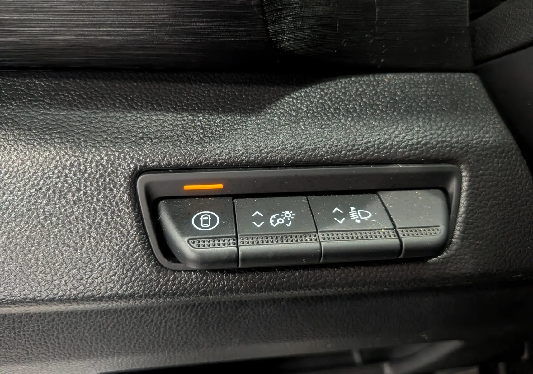 Gros plan sur les commandes de réglage d'éclairage et verrouillage du tableau de bord noir du Nissan Primastar Combi gris Highland.