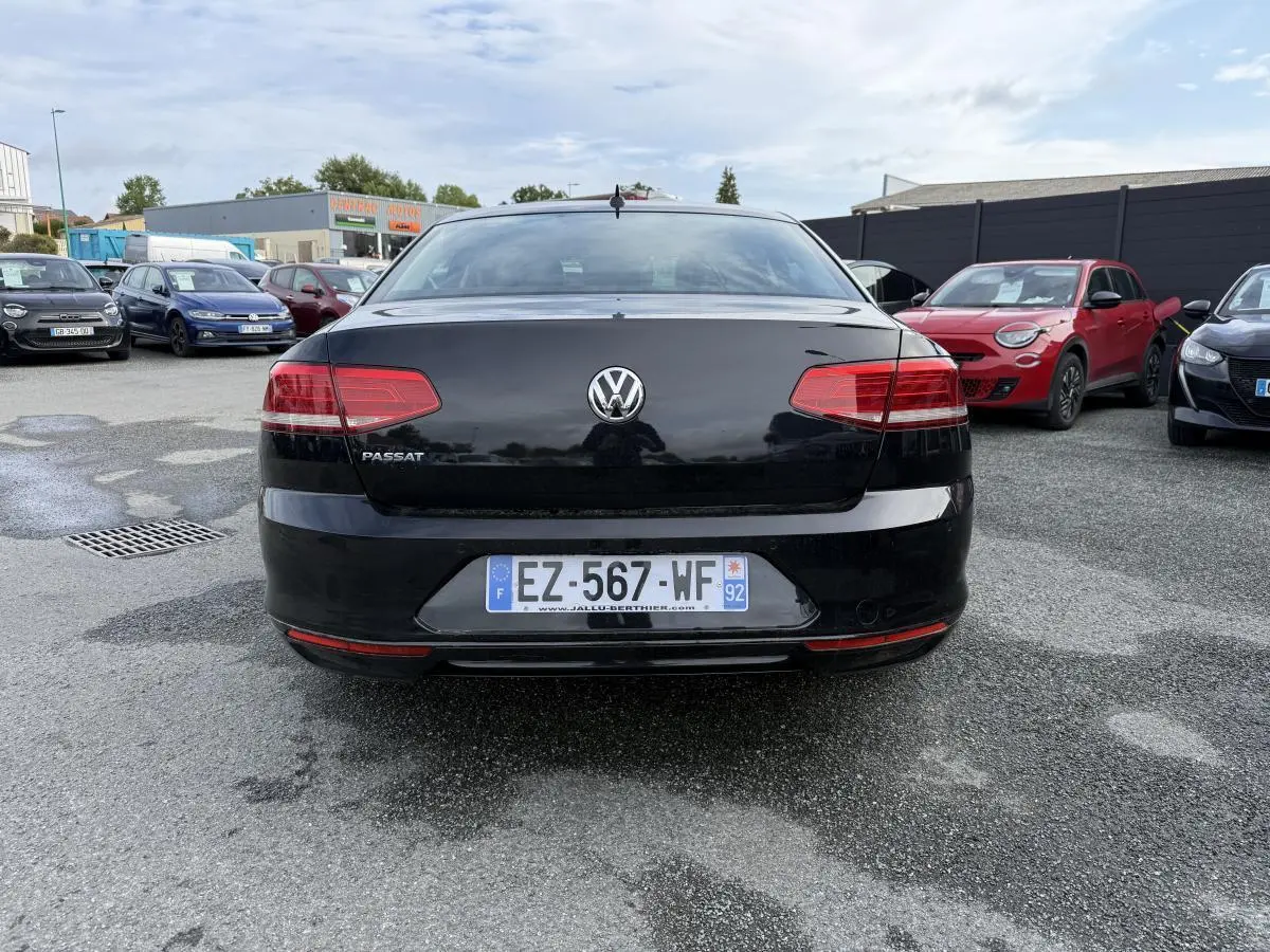 Vue arrière d'une Volkswagen Passat noire 2018 avec feux rouges et plaque d'immatriculation française visible.