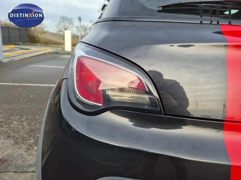 Gros plan sur le feu arrière gauche d'une Opel Adam Rocks noire avec bande rouge verticale sur le coffre.