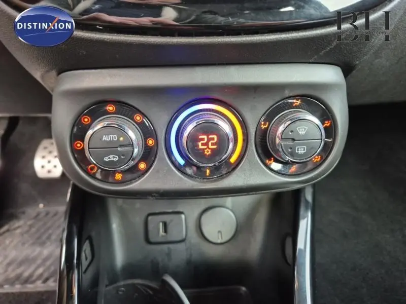 Détail du tableau de bord avec commandes de climatisation et affichage digital de la température à 22°C dans une Opel Adam Rocks noire.