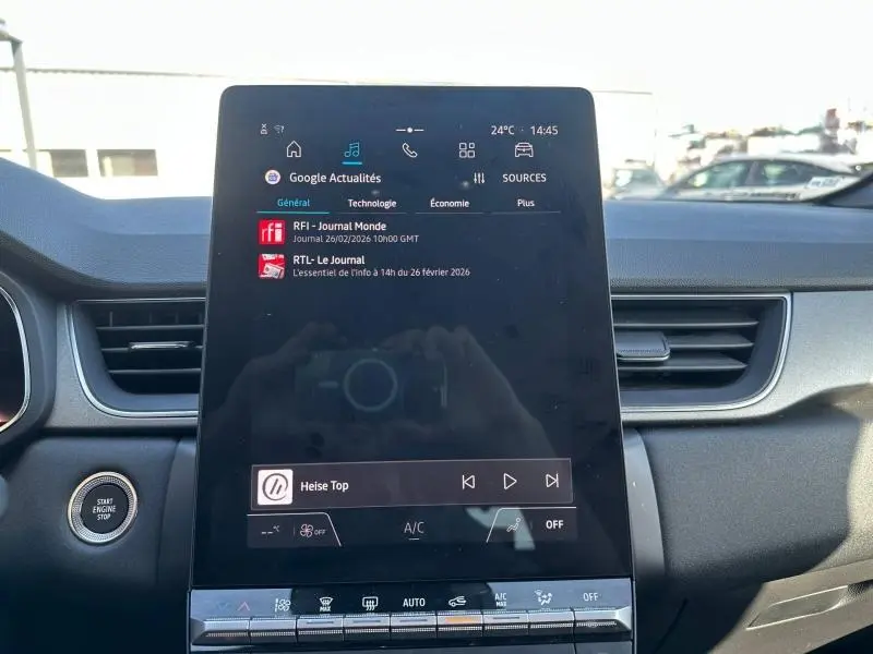 Vue intérieure centrée sur l'écran tactile du tableau de bord du Renault Captur 2025, avec commandes et bouton start/stop visibles.