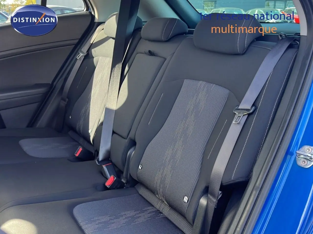Vue intérieure côté droit des sièges arrière en tissu noir du Kia Sportage bleu fusion métal avec ceinture de sécurité visible.