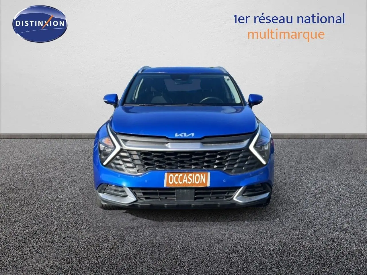 Vue frontale d’un KIA Sportage bleu fusion métal 2022 avec calandre noire et feux LED en forme de flèche.