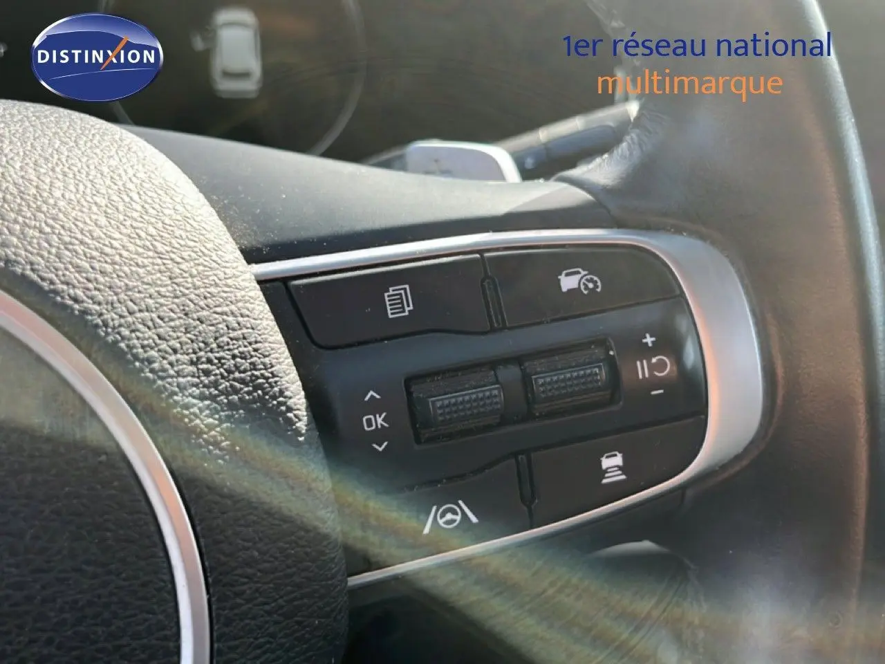 Gros plan sur les commandes au volant en cuir noir du Kia Sportage 2022, version bleu fusion métal.