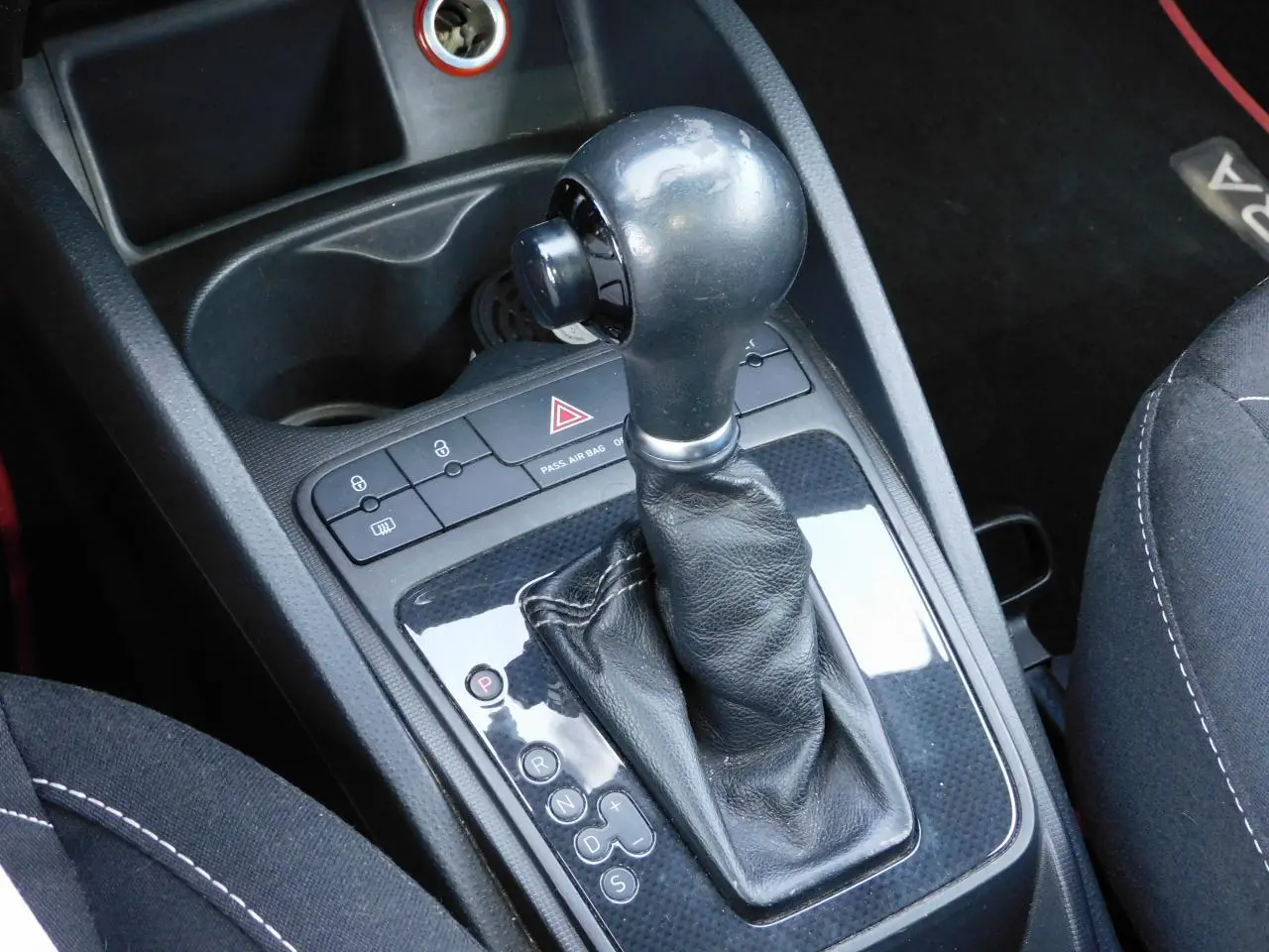Gros plan sur le levier de vitesse automatique cuir noir de la SEAT IBIZA Cupra 2011 avec console centrale brillante.