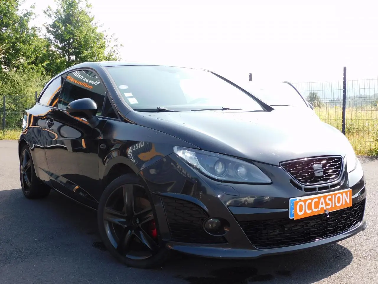 SEAT Ibiza Cupra noire vue en 3/4 avant droit, avec jantes noires et plaque "OCCASION" orange visible.