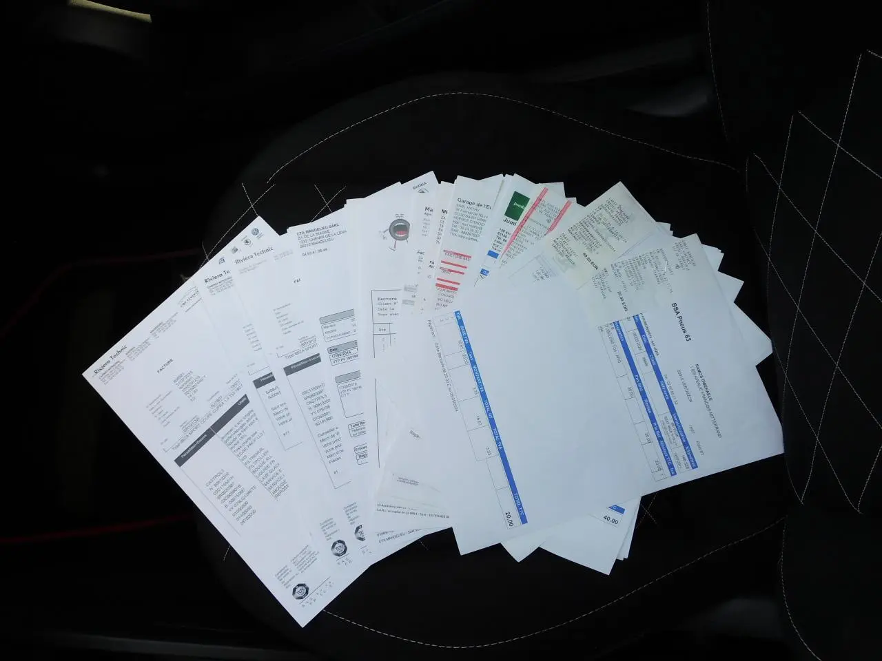 Désolé, l'image ne montre pas le véhicule SEAT IBIZA Cupra noir mais des documents posés sur un siège intérieur.