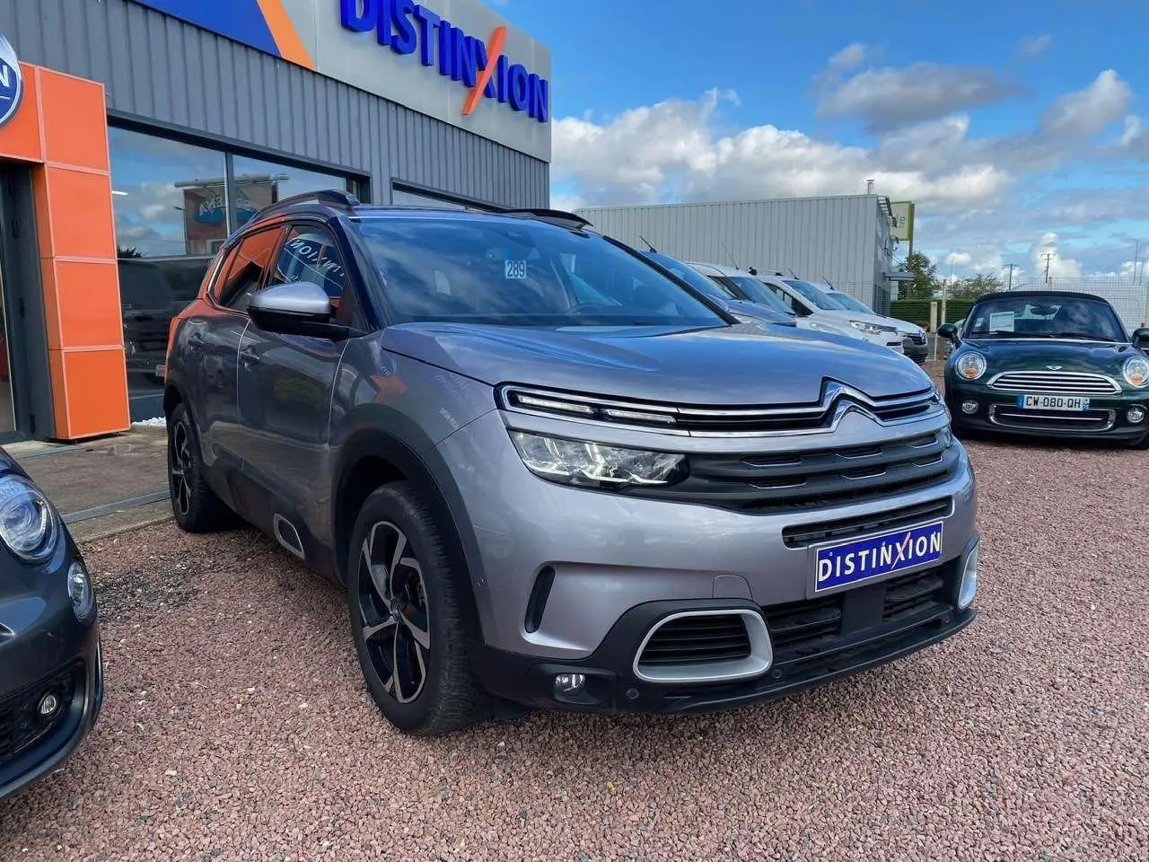 SUV Citroën C5 Aircross gris Artense vu en 3/4 avant droit avec calandre distinctive et jantes noires.