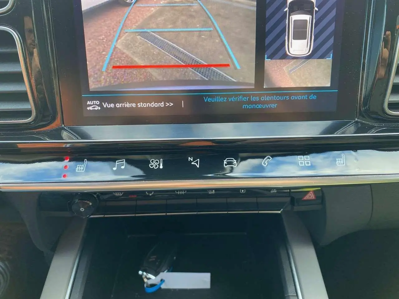 Gros plan sur l'écran tactile et la console centrale du Citroën C5 Aircross gris, affichant la caméra de recul en marche.