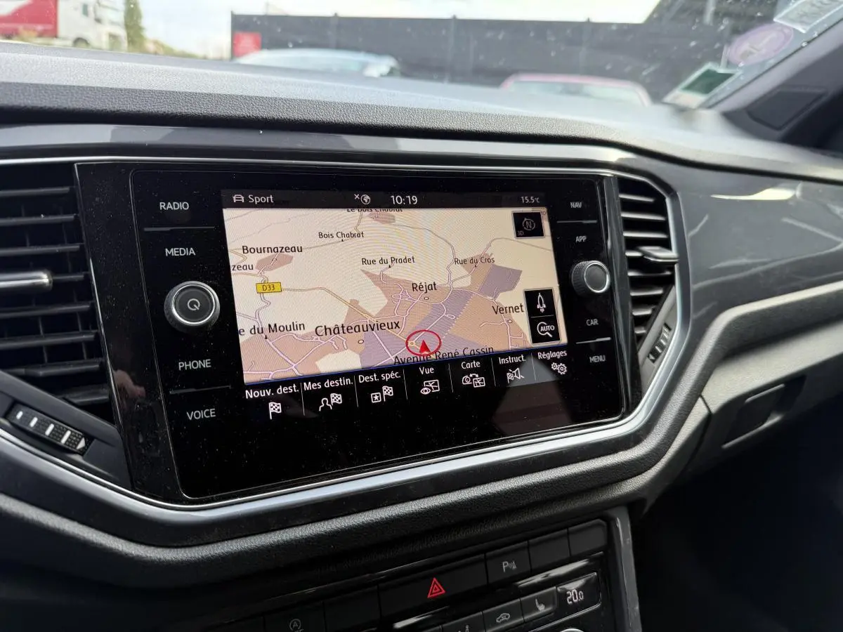 Écran central tactile du tableau de bord du Volkswagen T-Roc gris, affichant la navigation GPS en vue carte.