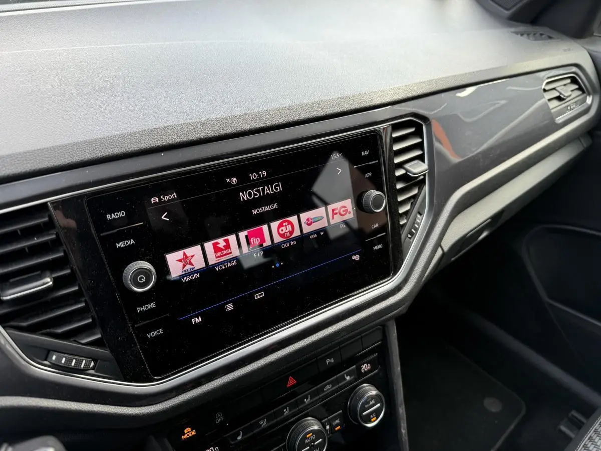 Vue intérieure du tableau de bord du Volkswagen T-Roc 2020 avec écran tactile et commandes de climatisation noires.