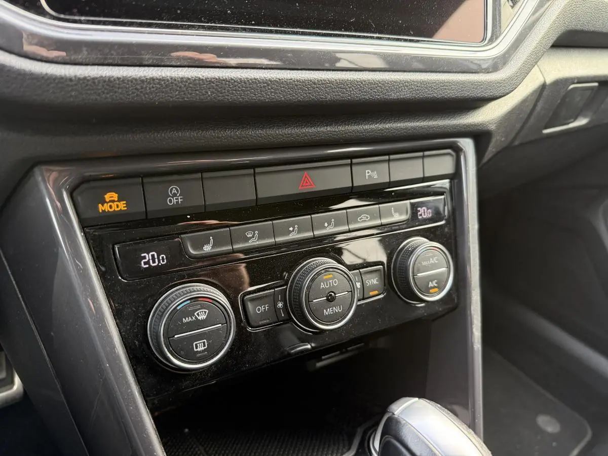 Détail de la console centrale noire du Volkswagen T-Roc 2020 avec commandes de climatisation automatique et bouton mode actif.