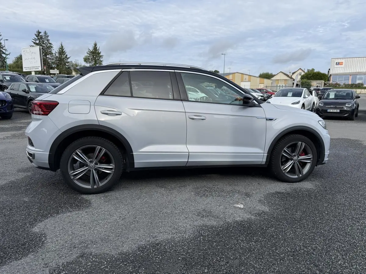 Volkswagen T-Roc 1.5 TSI R-Line blanc pur vue de profil côté gauche avec jantes alliage et étriers rouges.