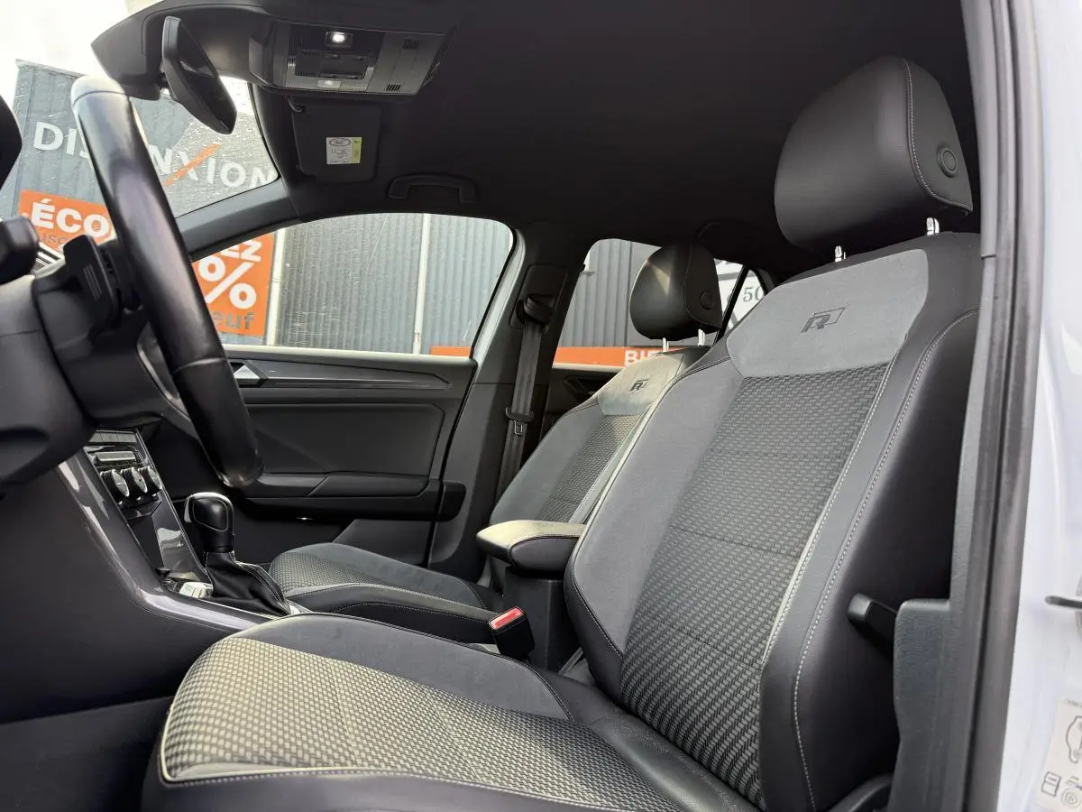 Intérieur avant du Volkswagen T-Roc R-Line 2020, sièges sport gris avec logo R brodé, volant et console visibles.