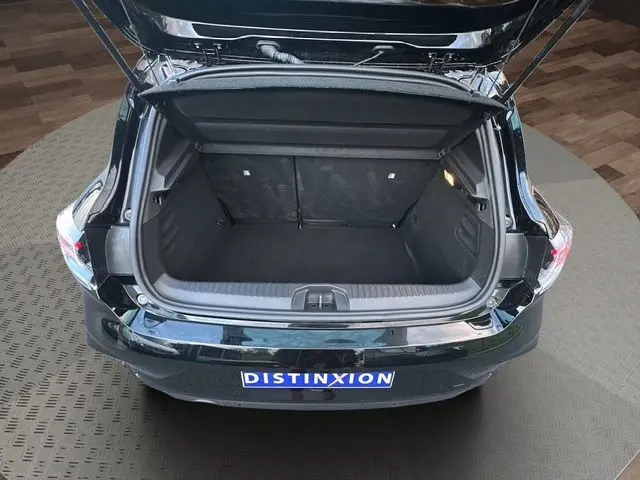 Vue arrière ouverte du coffre noir de la Renault Clio V 1.5 Blue DCI 100 Evolution 2025, intérieur spacieux et propre.
