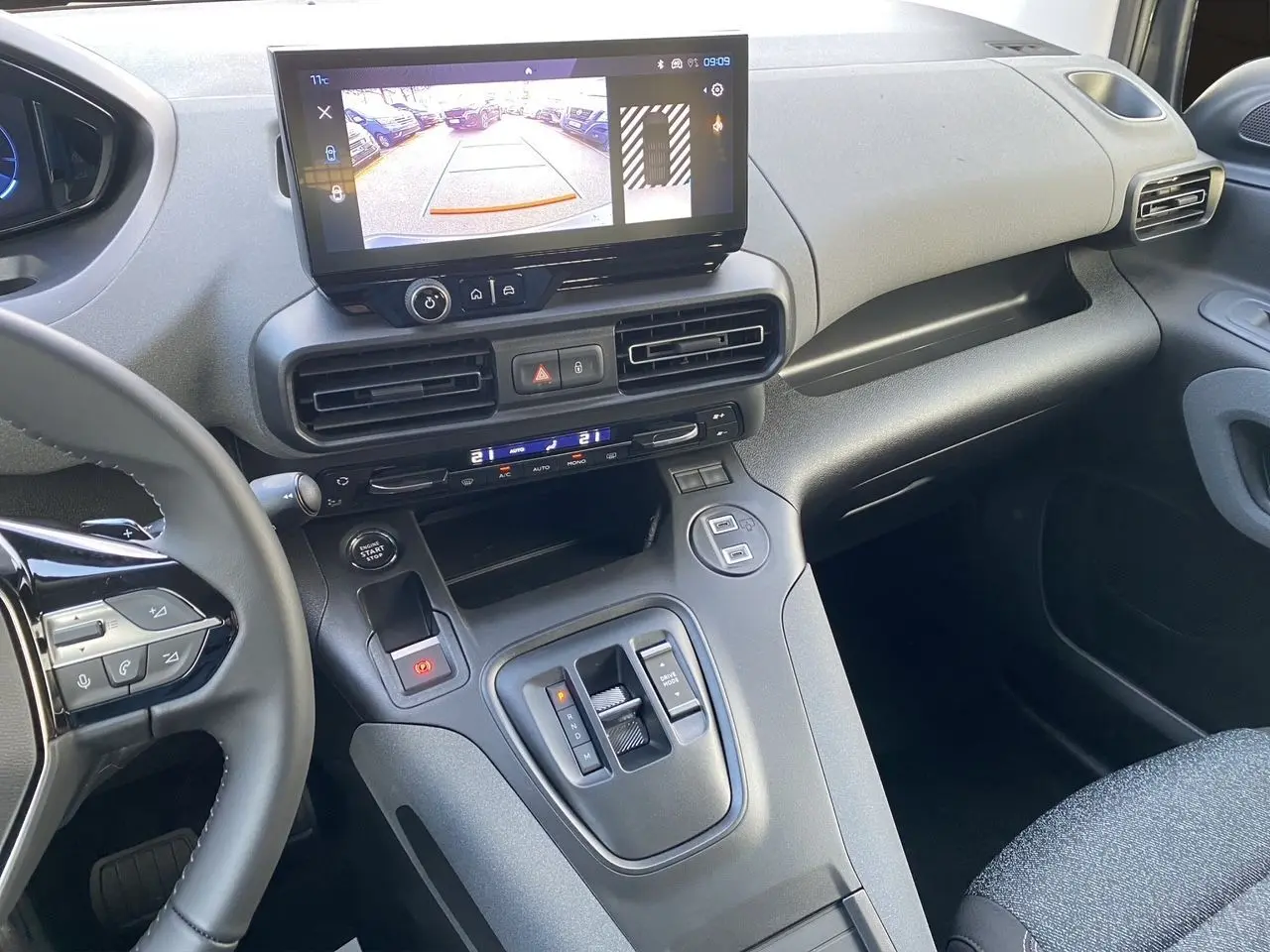 Vue intérieure côté passager du tableau de bord gris noir du Peugeot Rifter 2025 avec écran tactile et caméra de recul affichée.