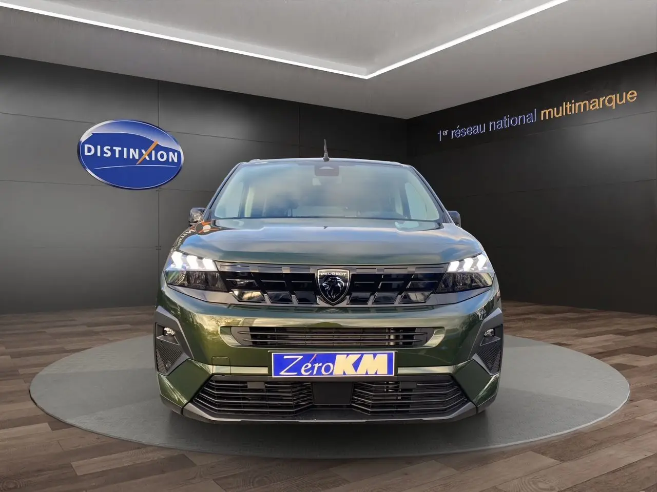 Vue frontale du Peugeot Rifter 2025 en vert Sirkka, avec calandre noire et phares LED allumés.