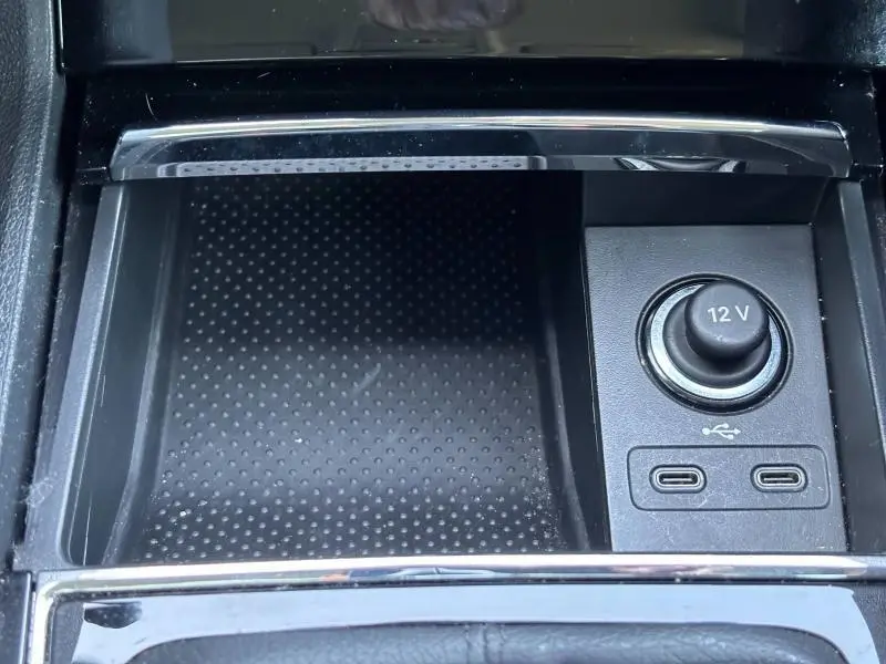 Prise 12V et double port USB en gros plan dans la console centrale du Skoda Karoq blanc Lune métallisé 2024.